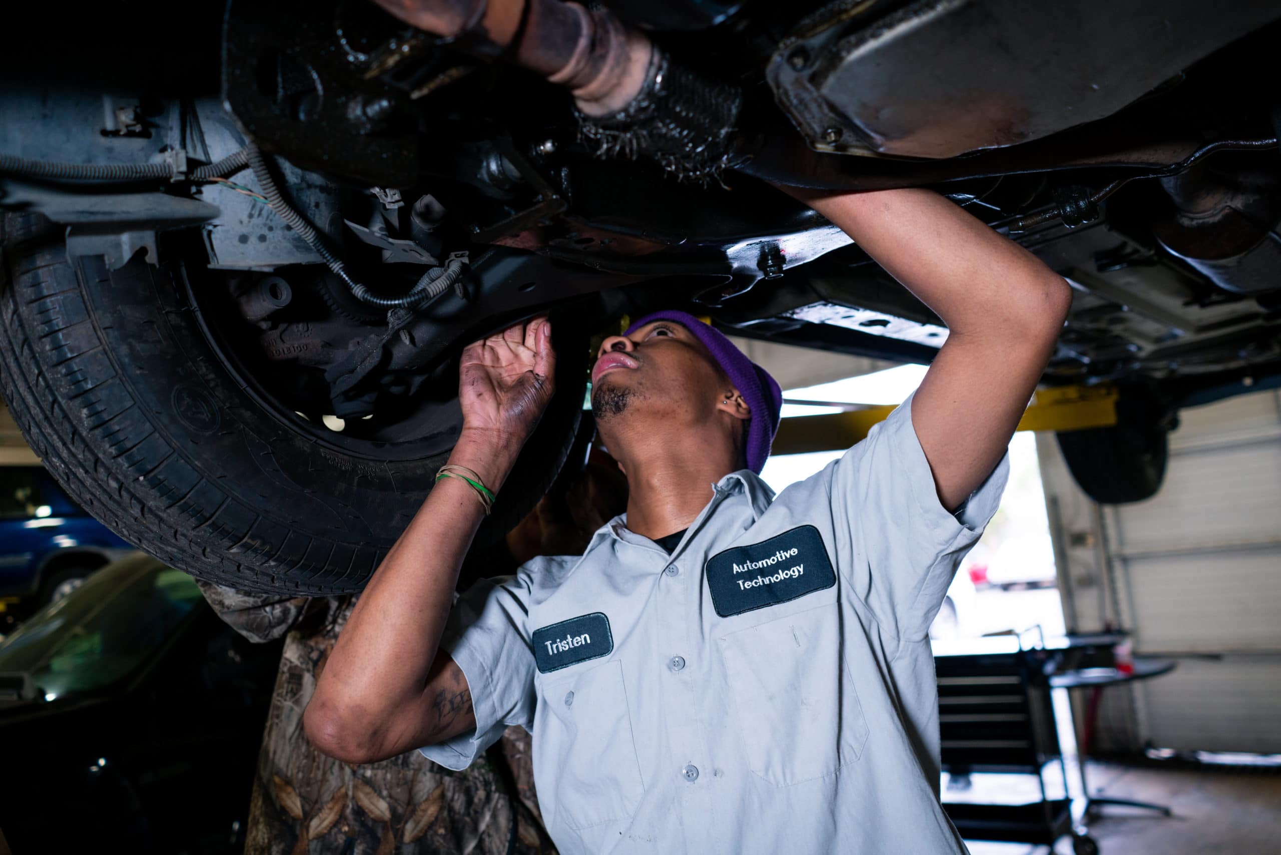 A student working on a vehicle in an auto mechanic class.