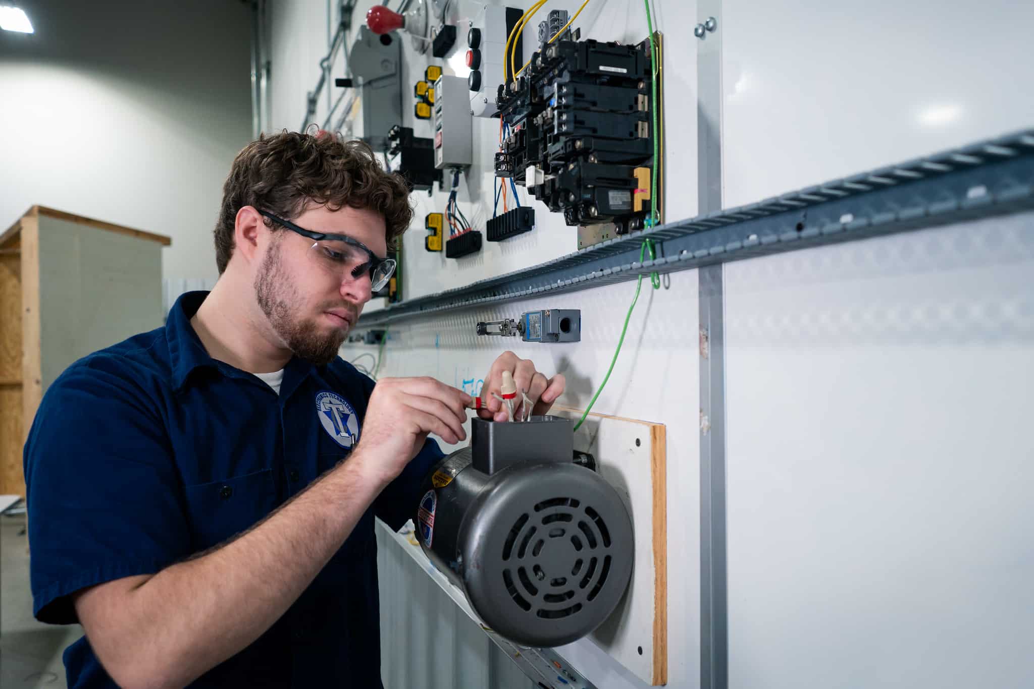 Student working on electrical equipment earning their electrical technology degree or certificate.