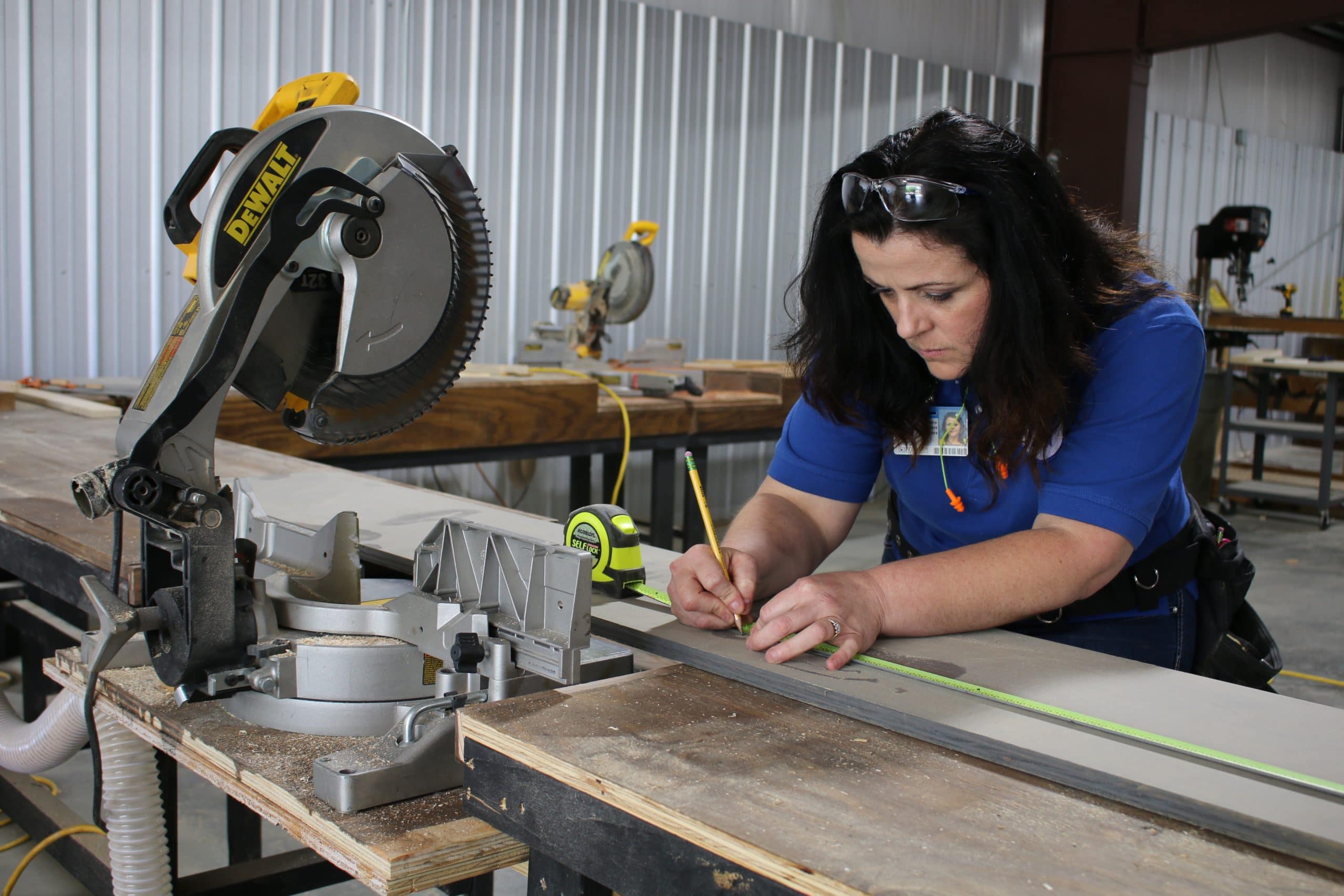 Construction college student measuring before making a cut