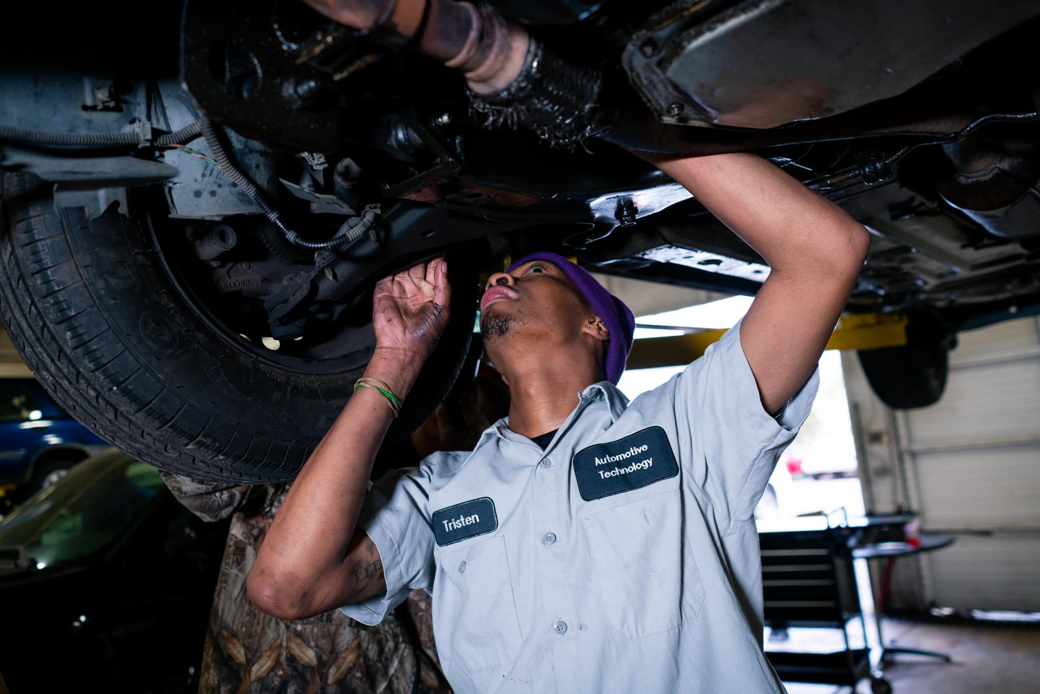 Automotive student working under lifted vehicle