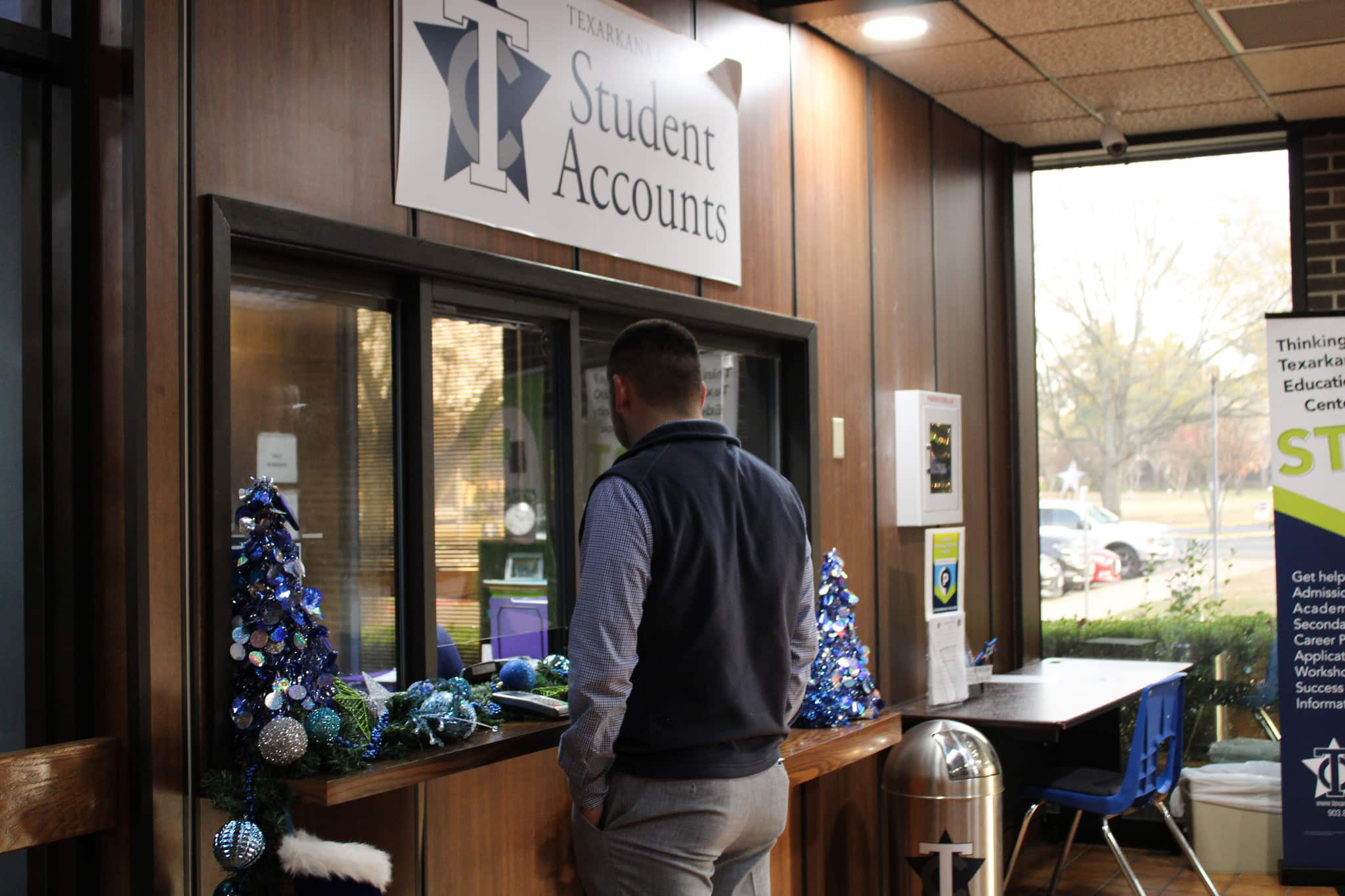 Student visiting the Student Accounts window in the Administration building