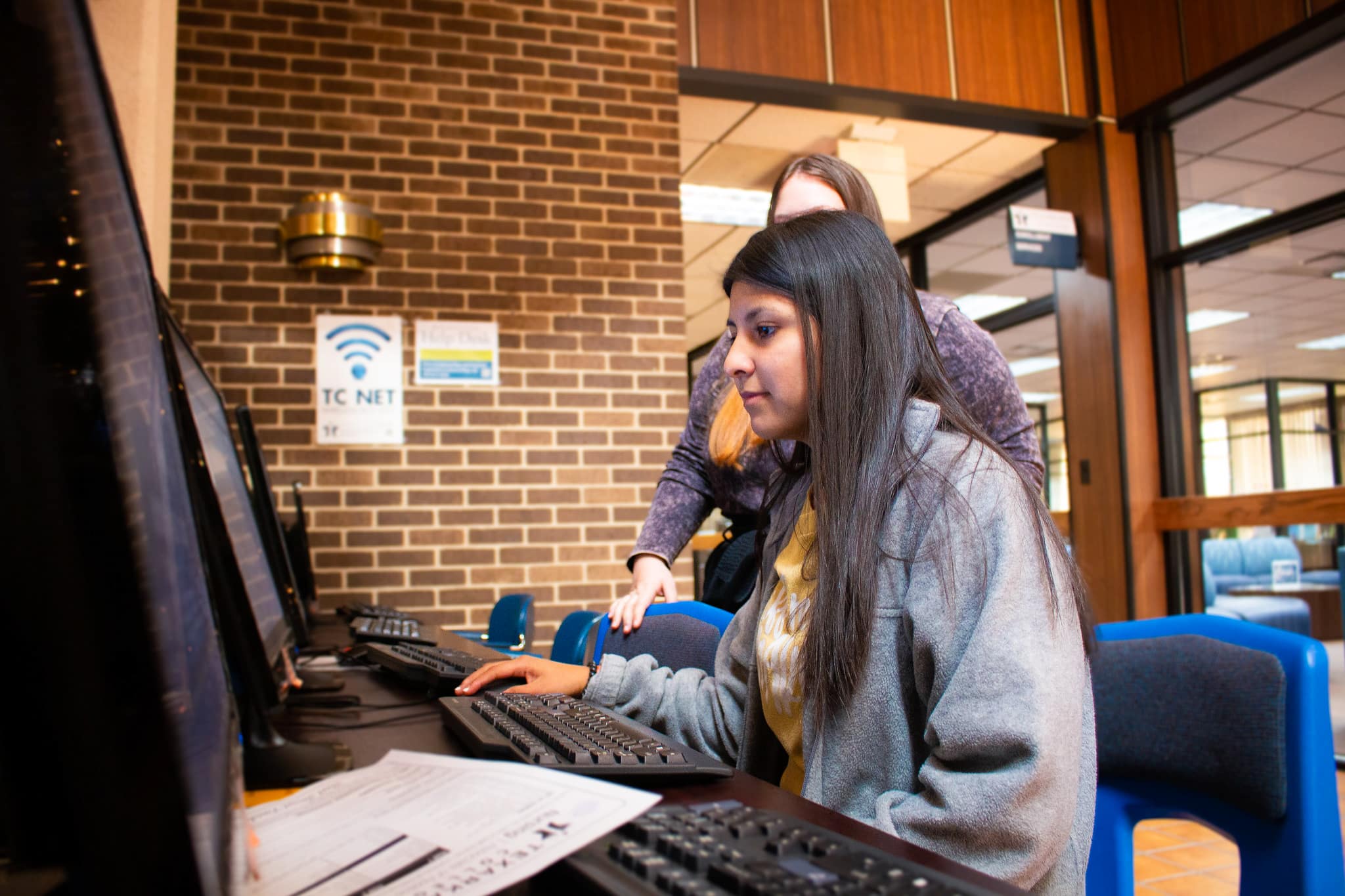 student completing application at enrollment services computer